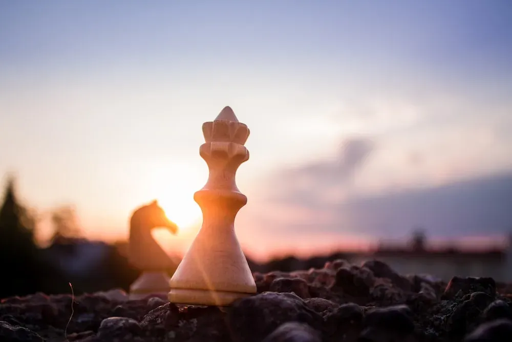 bishop chess piece on black rock at daytime