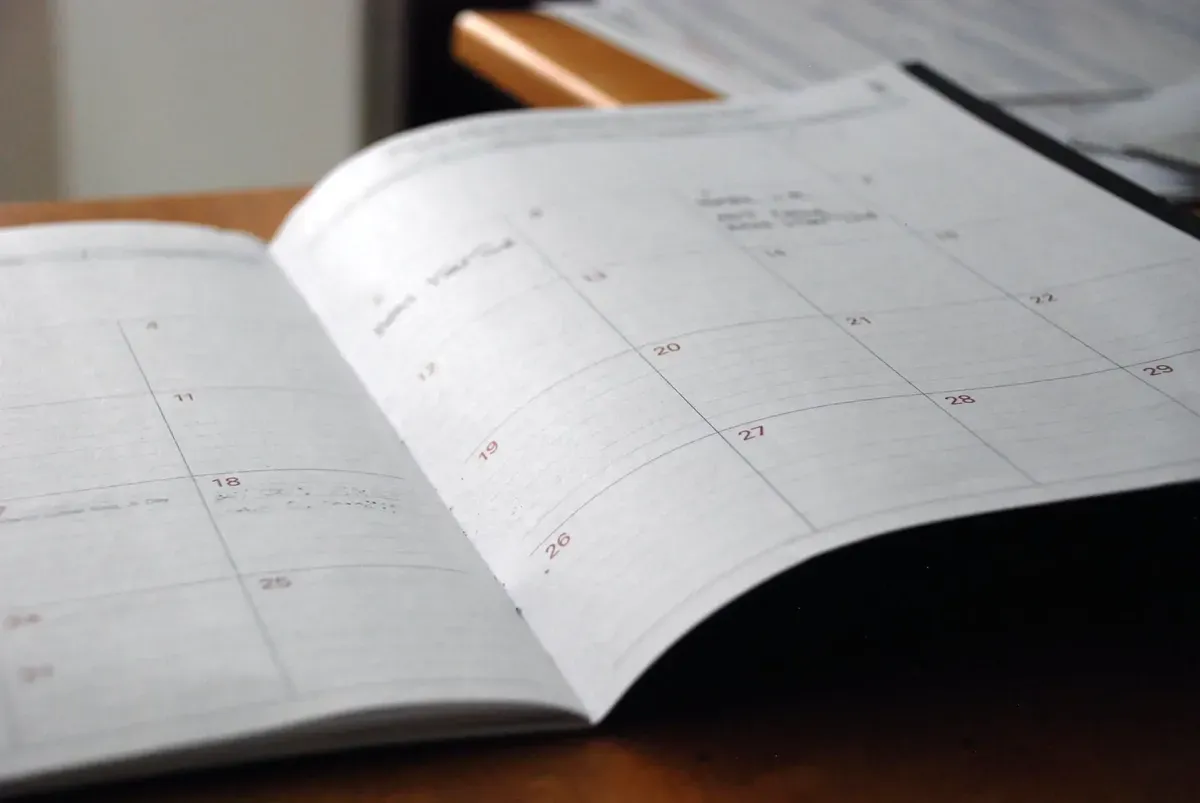 Open desk calendar planner on a wooden table