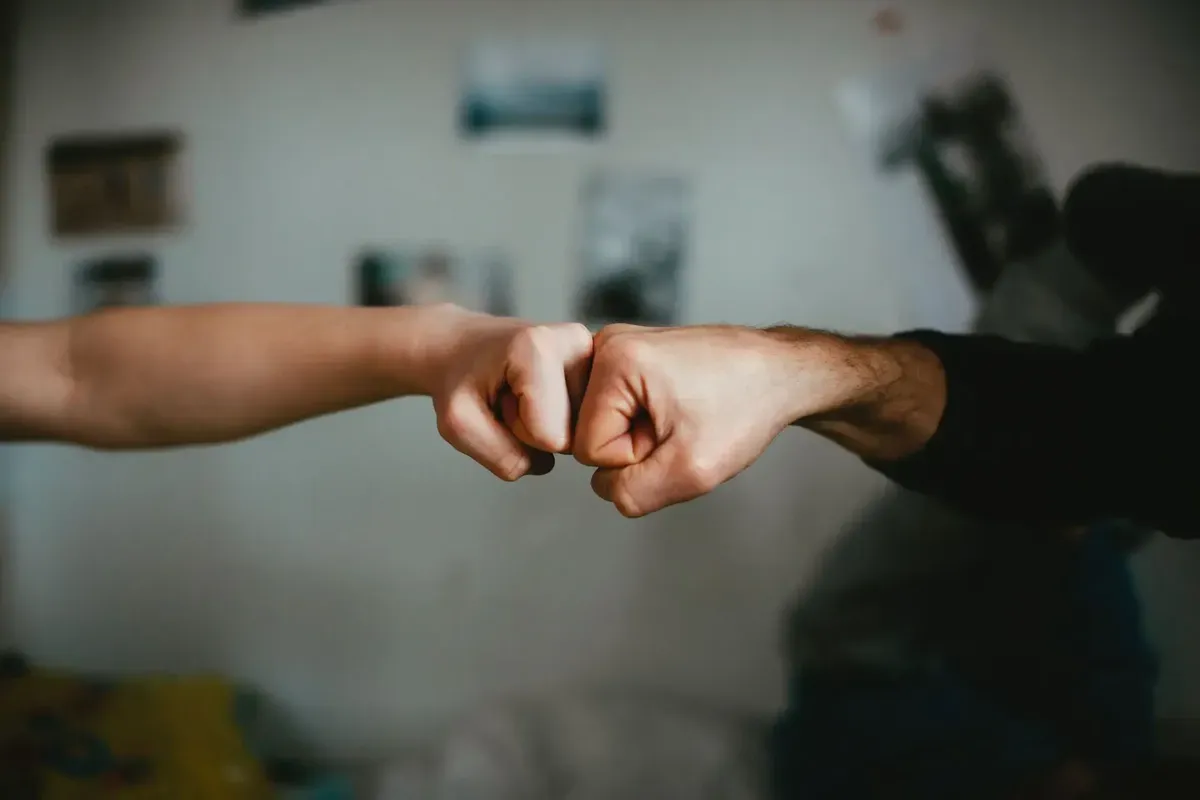 Two people fist-bumping