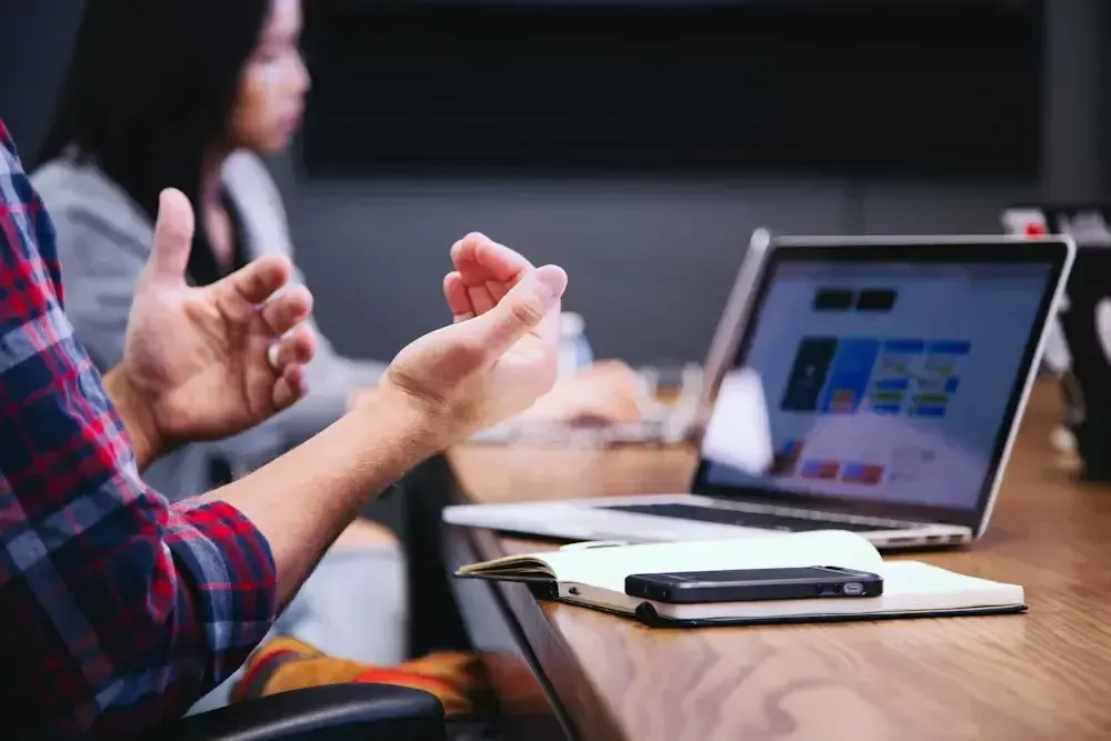 Colleagues in an animated discussion at a laptop during a meeting