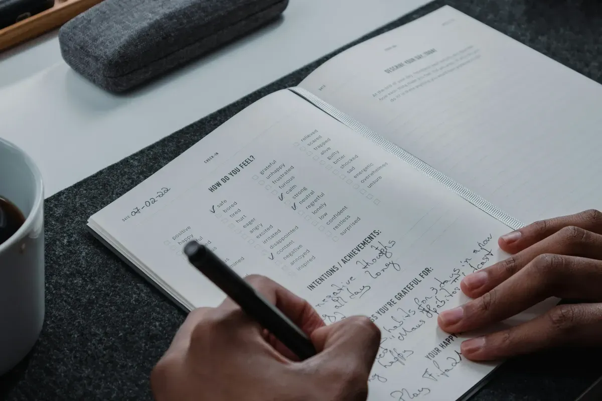 Hand writing in a gratitude and mood-tracking journal