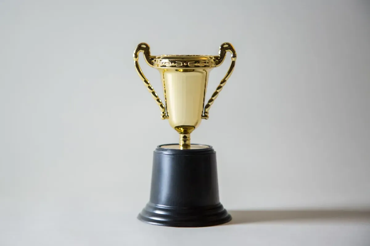 Gold trophy displayed on a black pedestal