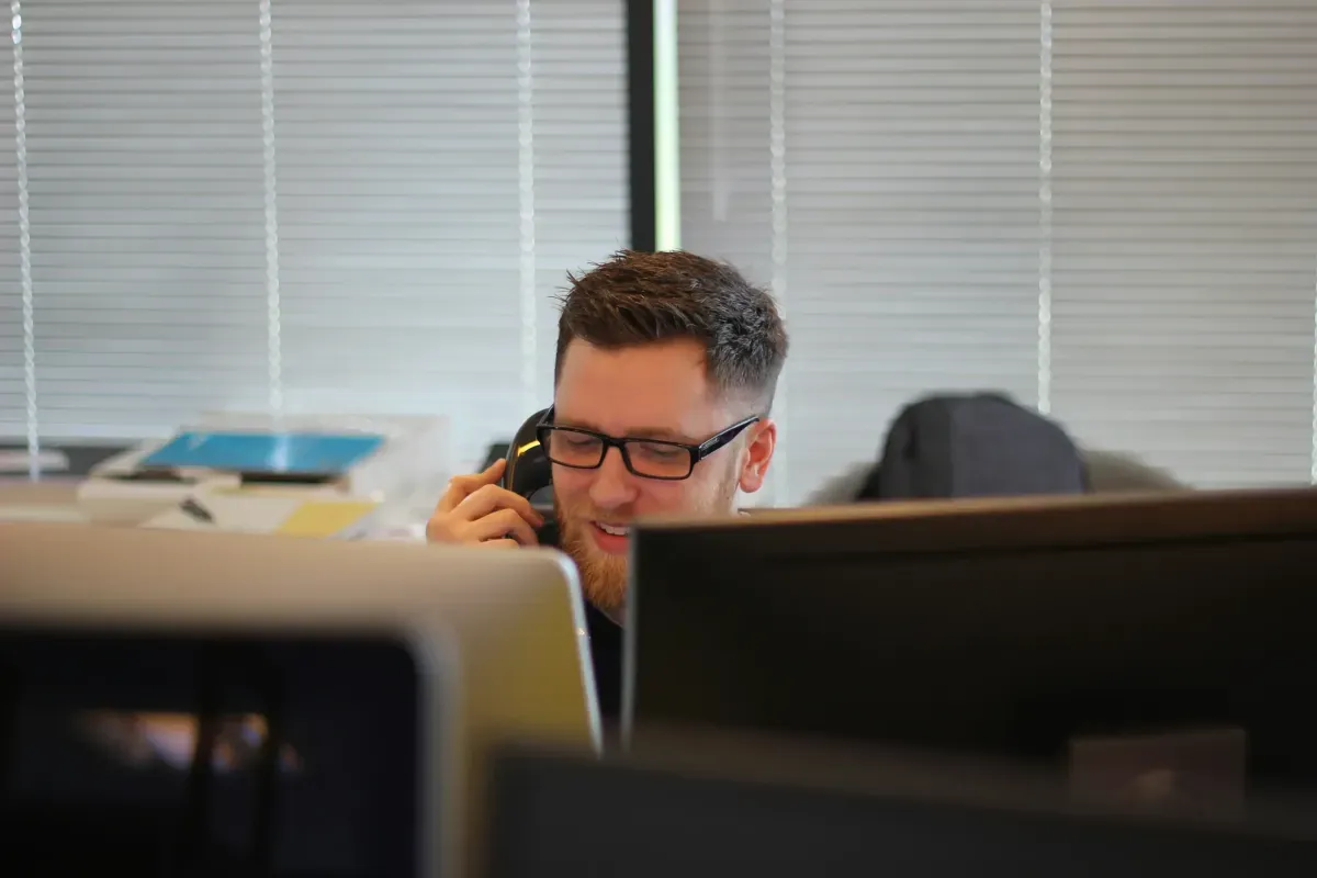 man on the phone at his office desk