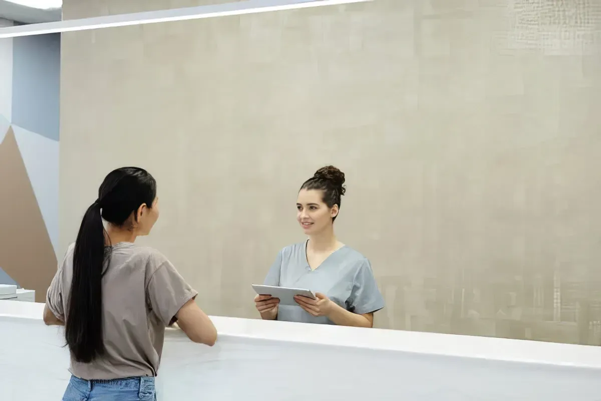 Free stock image of a woman looking at herself in a mirror and smiling.