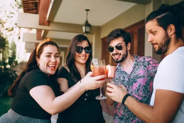 Free stock image of a group of four friends toasting their drinks at a party.
