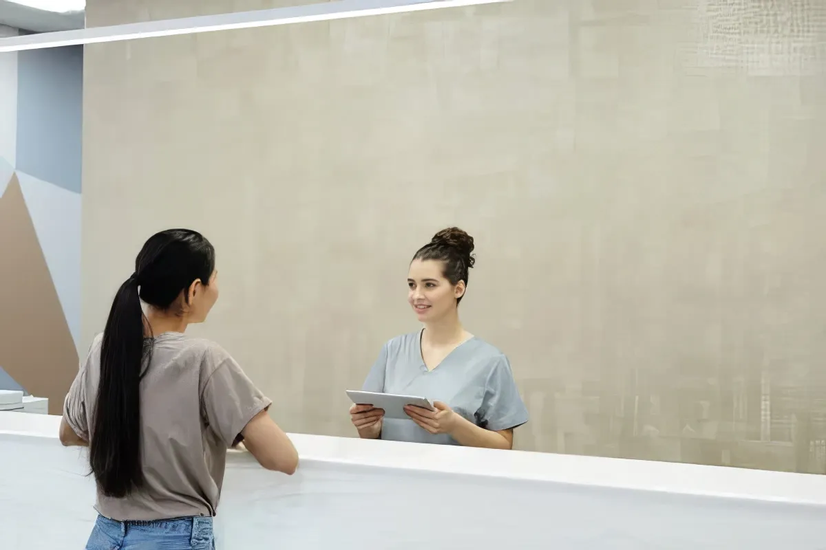 Free stock image of a woman looking at herself in a mirror and smiling.